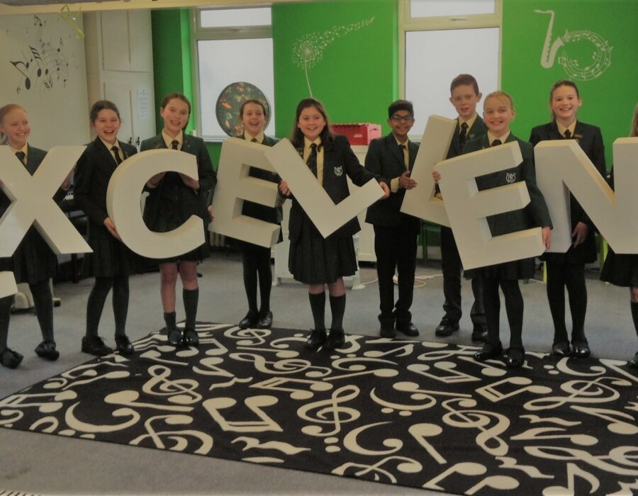 prep 6 children holding letters that spell excellent